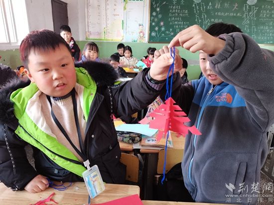 孩子們在展示自己的剪紙作品。.jpg.jpg